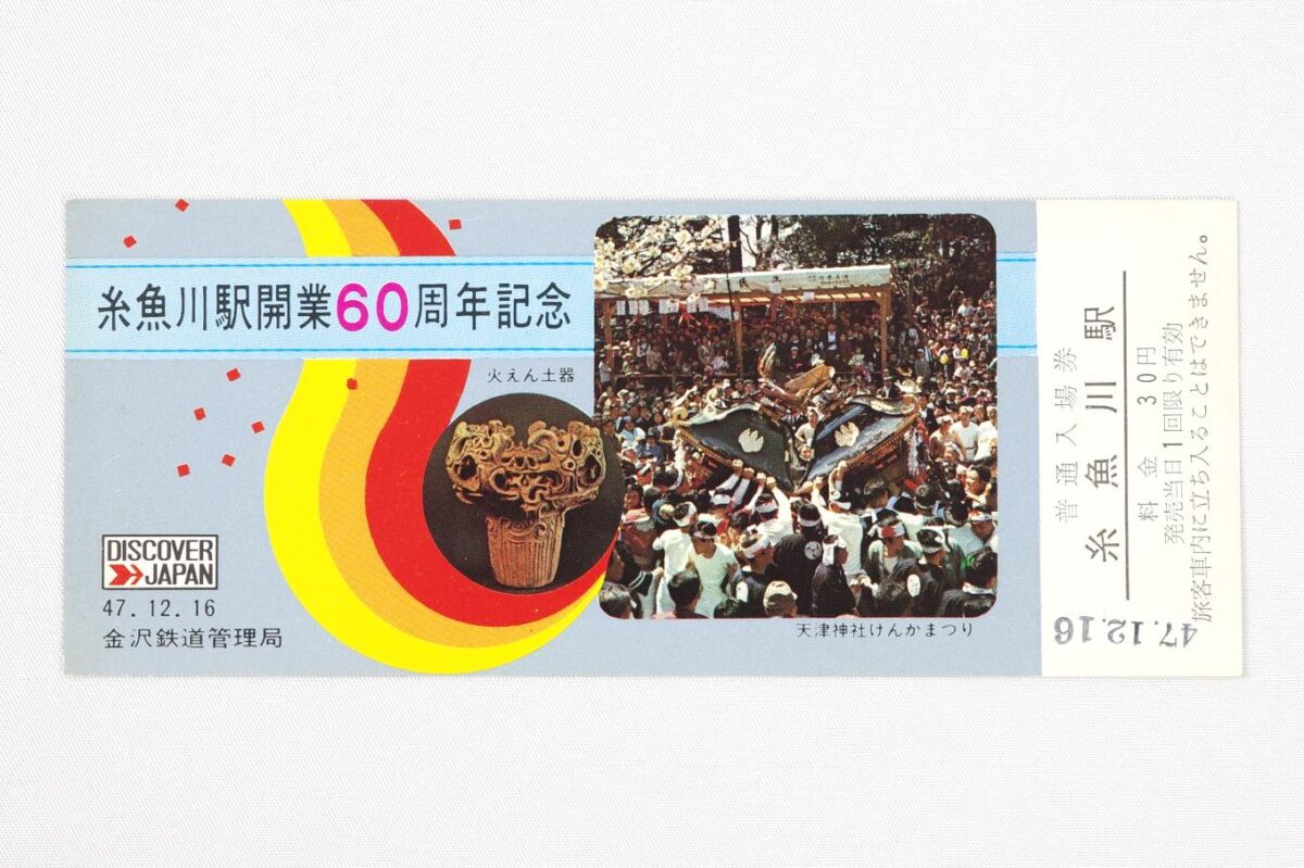 入場券の表面。左上に「糸魚川駅開業60周年記念」の文字があり、中央付近に小さく火焔型土器の写真、右側に糸魚川けんか祭りの写真が置かれている。サイズは14.7 × 6 cm。