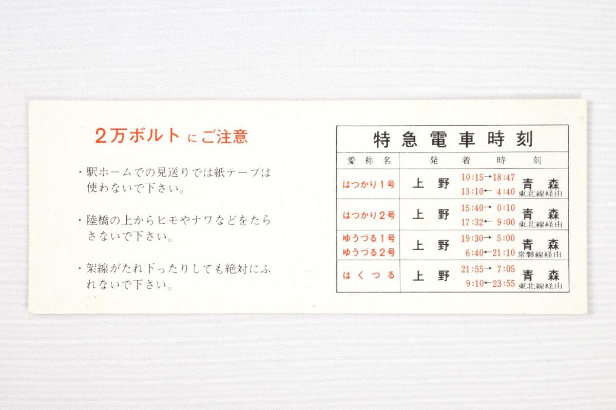 記念券の裏面。左側に2万ボルトにご注意として、感電につながるホームでの紙テープ使用や、陸橋上から紐を垂らすなどをしないよう記されている。右側には上野と青森を結ぶ4往復の特急電車の時刻表が記されている。