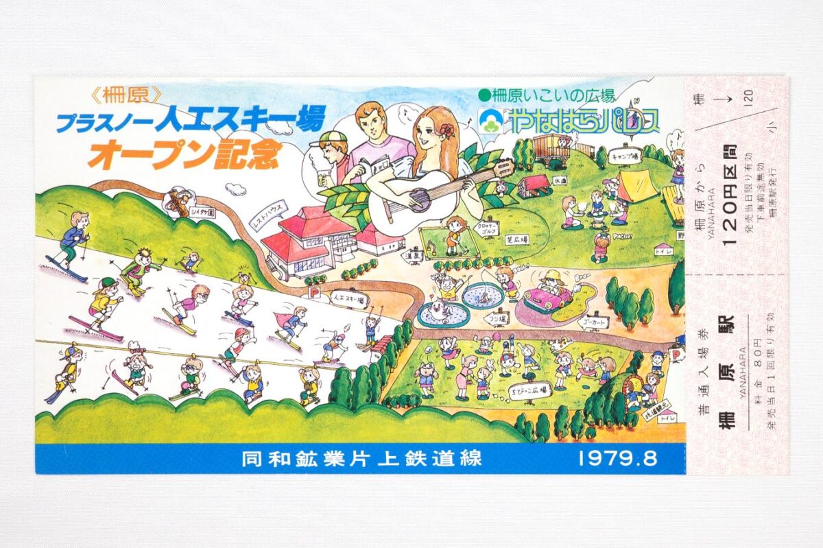 記念切符の表面。幅が20cmを超える大きな券面は「やなはらパレス」全体のイラストになっていて、各種施設やそれを利用する人たちがコミカルに表現されている。右側にはおまけのように柵原から120円区間の乗車券と、柵原駅の入場券が付いている。サイズは21.9 × 11.6cm。
